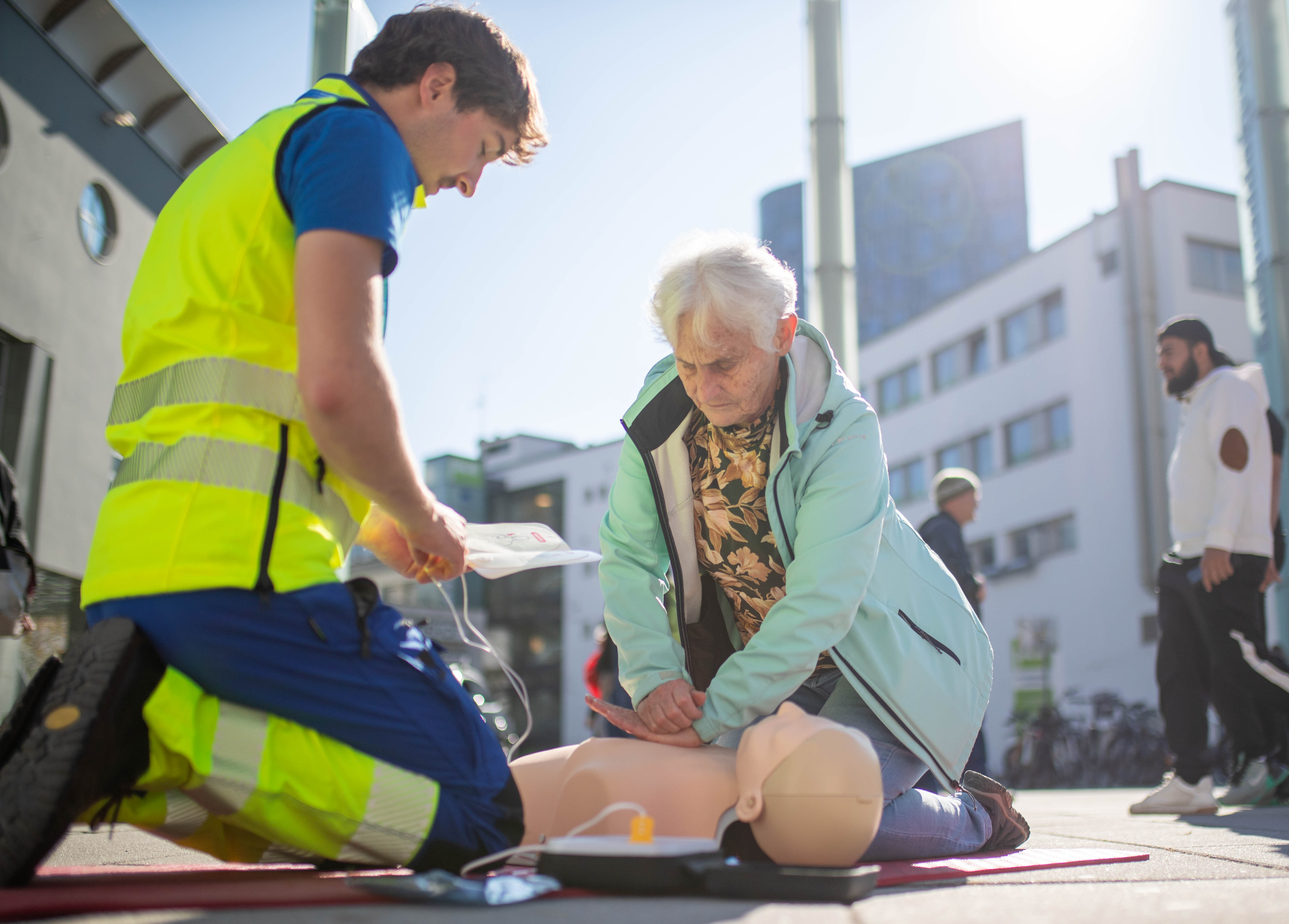 Eine Teilnehmerin übt mit Unterstützung einer IGNI-Trainerin die Herzdruckmassage